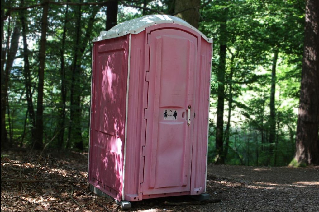 Moderne mobiele toiletten geplaatst op een evenement met mensen eromheen